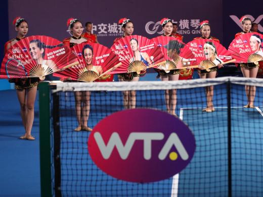 The dancers display fans with the faces of the Zhuhai competitors (Getty)