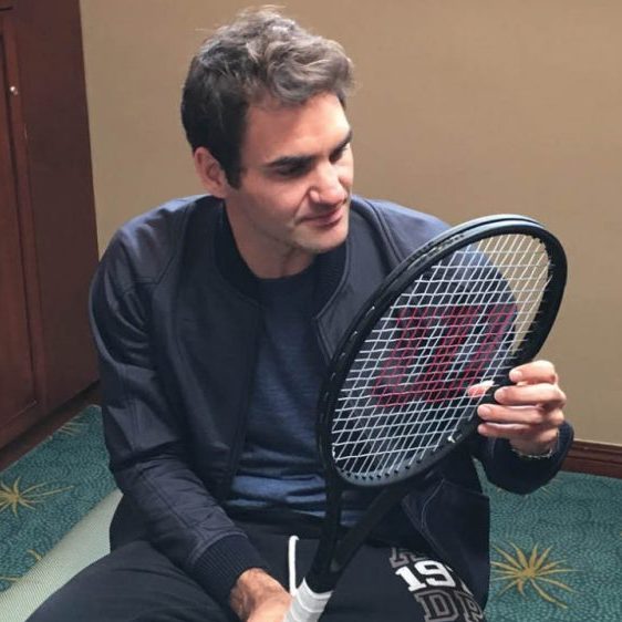 Roger Federer looking at his strings